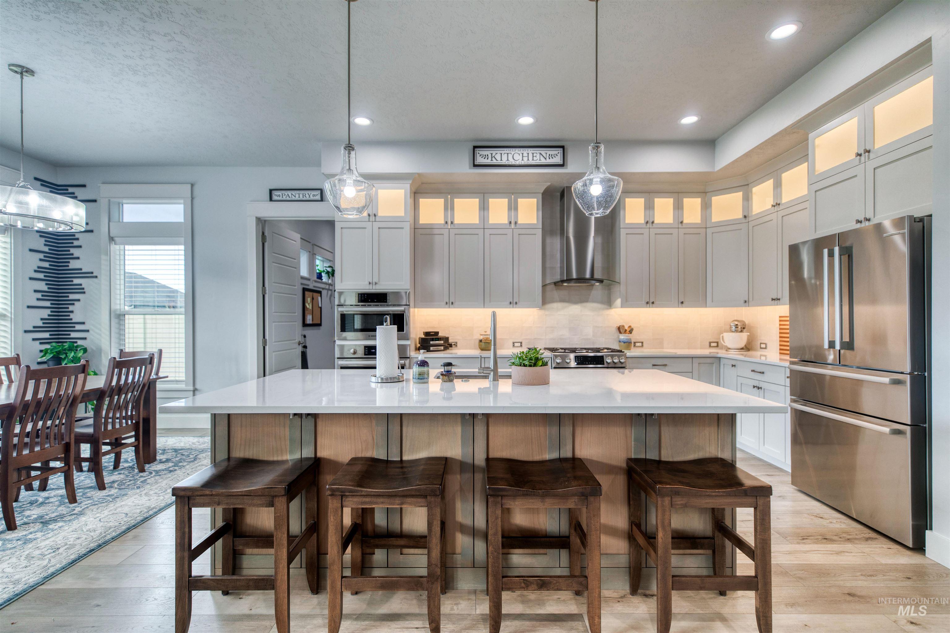 795 East Rio Chico Drive Kuna, ID 83634 - Photo 5 of 34 Kitchen featuring stainless steel appliances, hanging light fixtures, light wood-style floors, white cabinetry, and recessed lighting