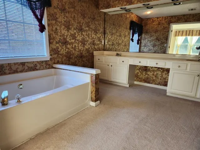 a bathroom with a tub sink and mirror