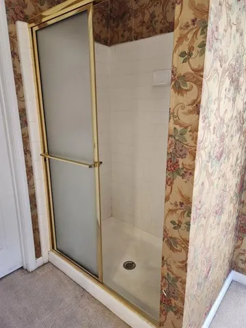 a bathroom with a glass door shower