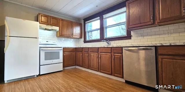 a kitchen with stainless steel appliances granite countertop a stove a sink and a refrigerator