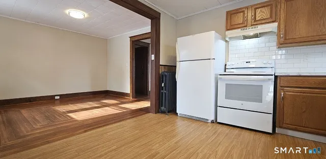 a view of a kitchen with wooden floor and electronic appliances