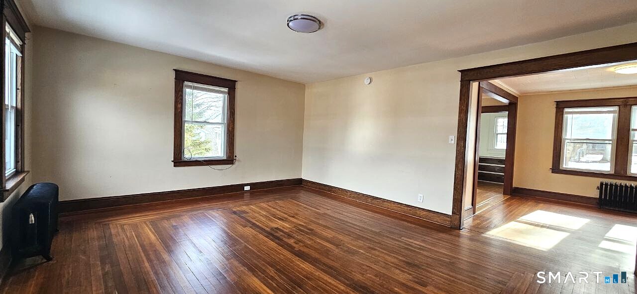 49 Bingham Street Bristol, CT 06010 - Photo 16 of 27 an empty room with wooden floor and windows