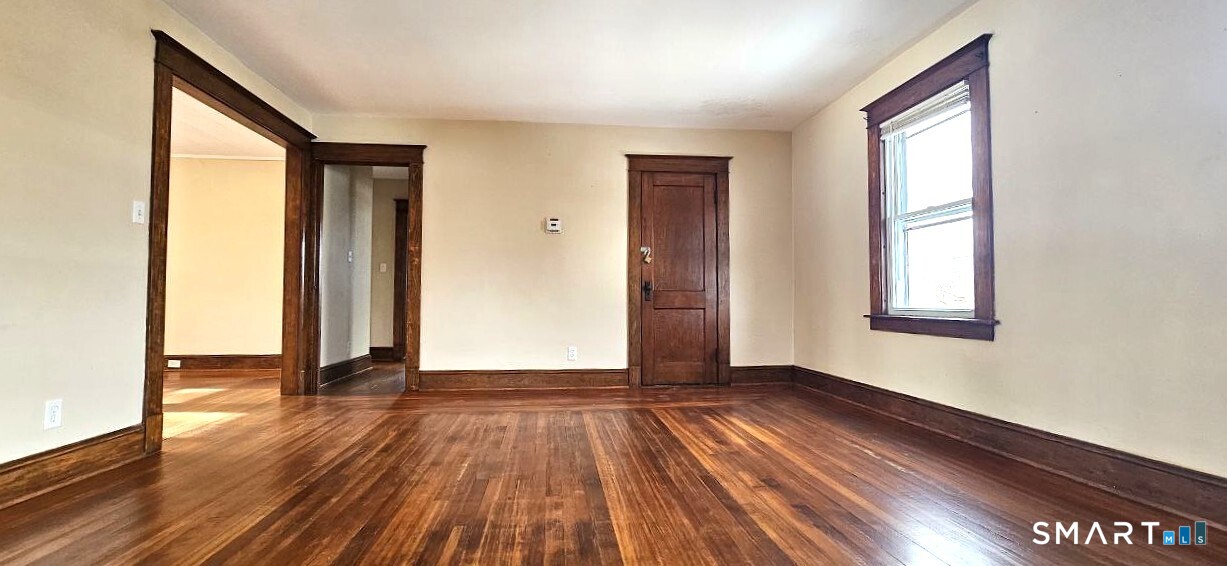 49 Bingham Street Bristol, CT 06010 - Photo 6 of 27 an empty room with wooden floor and windows