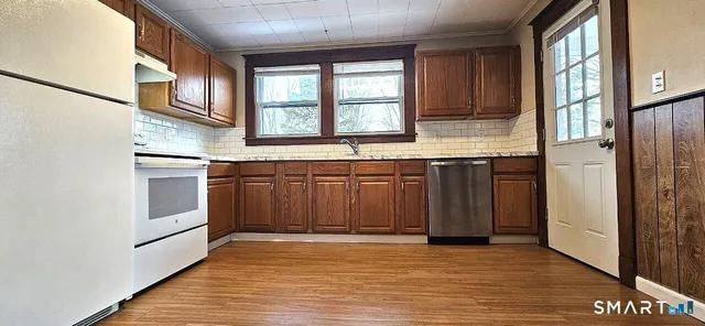 a kitchen with stainless steel appliances granite countertop a stove a sink and a refrigerator