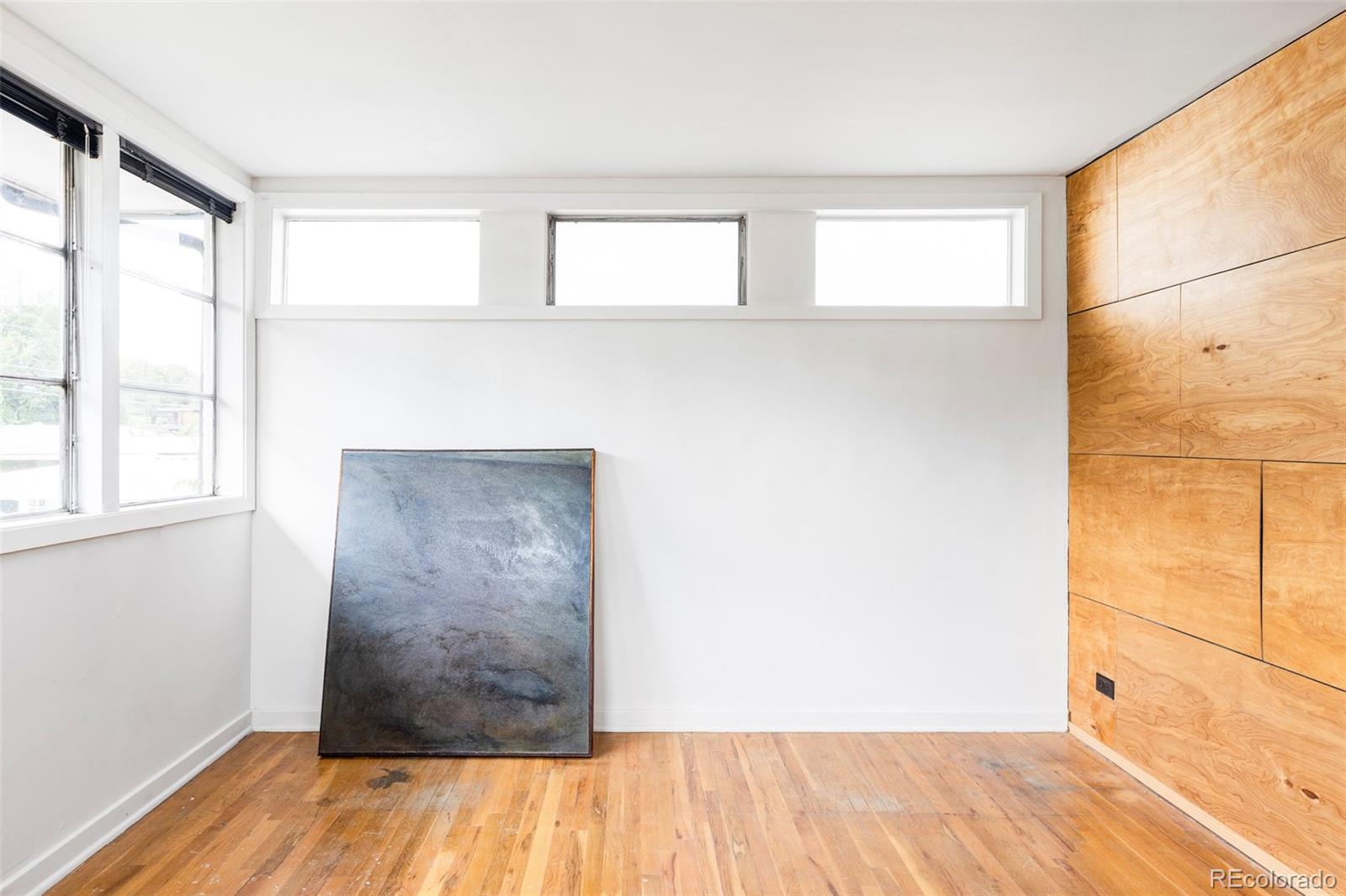 3025 Glencoe Street Denver, CO 80207 - Photo 12 of 26 a view of a room with wooden floor and small window