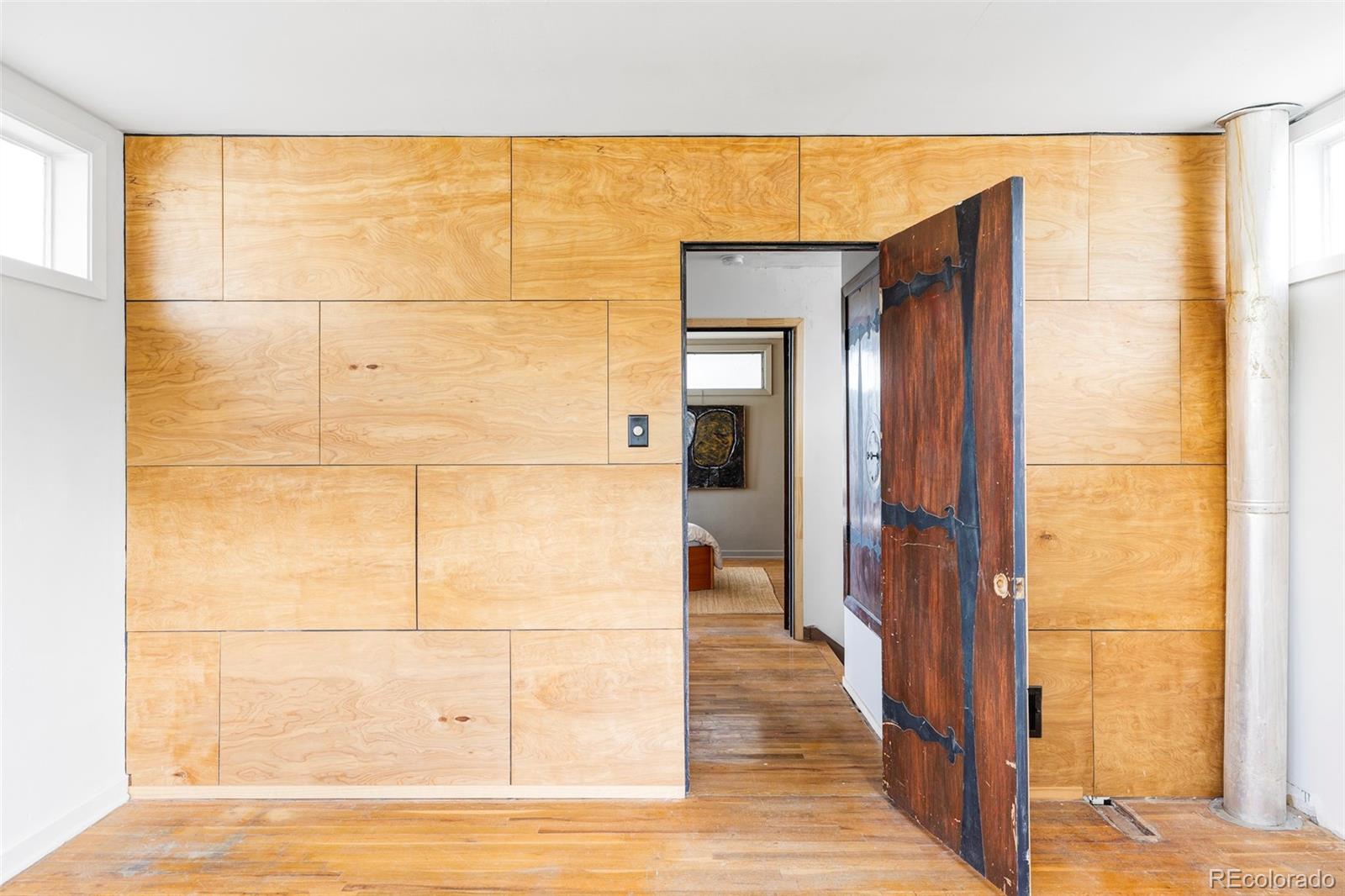 3025 Glencoe Street Denver, CO 80207 - Photo 13 of 26 a view of a hallway with wooden floor and a bathroom
