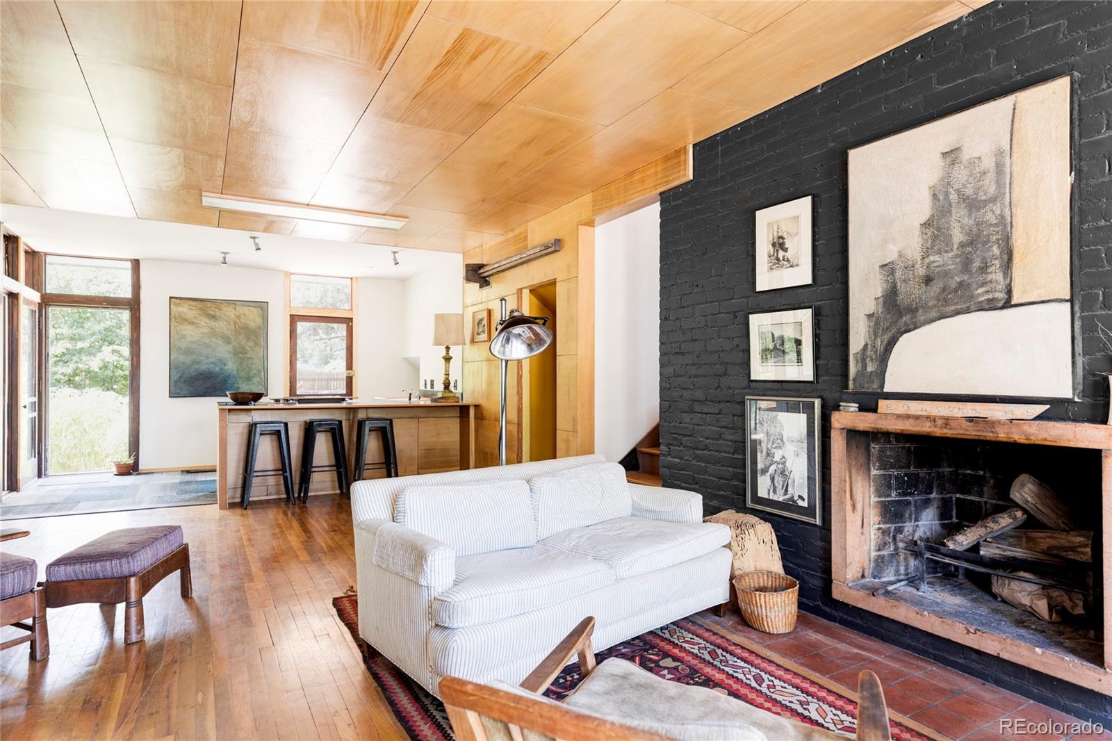 3025 Glencoe Street Denver, CO 80207 - Photo 2 of 26 a living room with furniture a fireplace and a floor to ceiling window