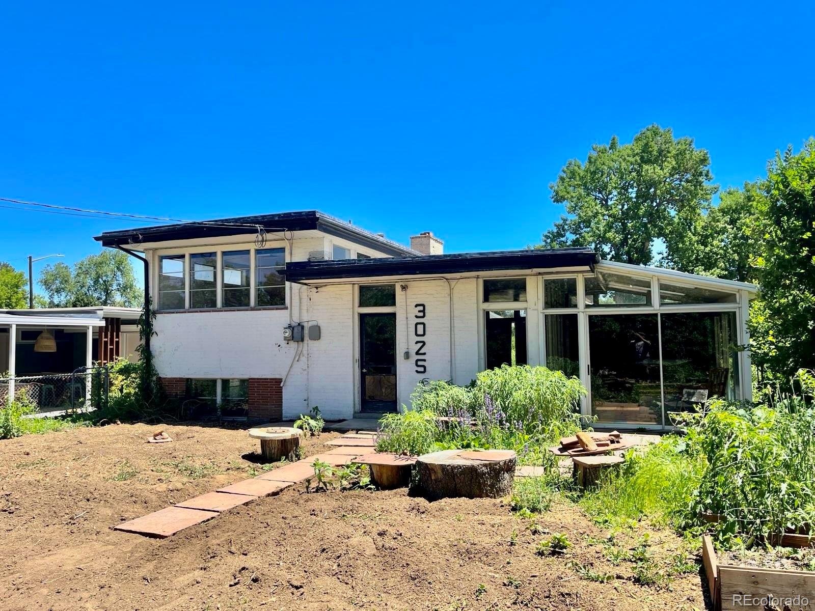 3025 Glencoe Street Denver, CO 80207 - Photo 23 of 26 a front view of a house with a yard