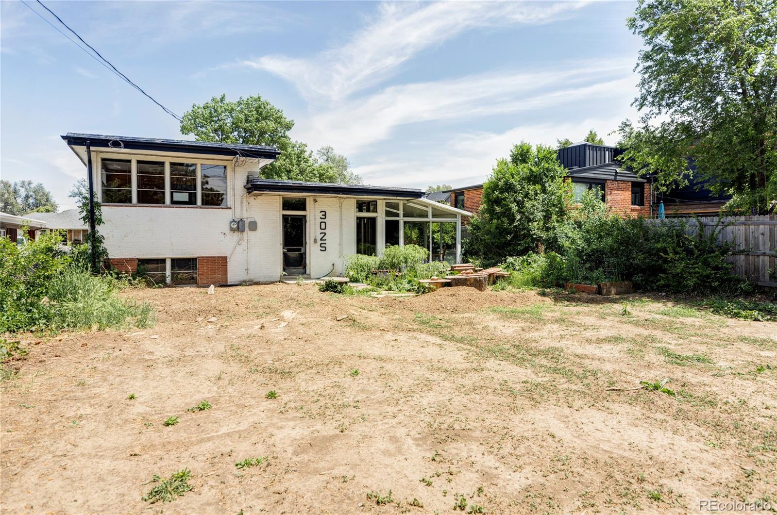 3025 Glencoe Street Denver, CO 80207 - Photo 24 of 26 a front view of house with yard and trees around