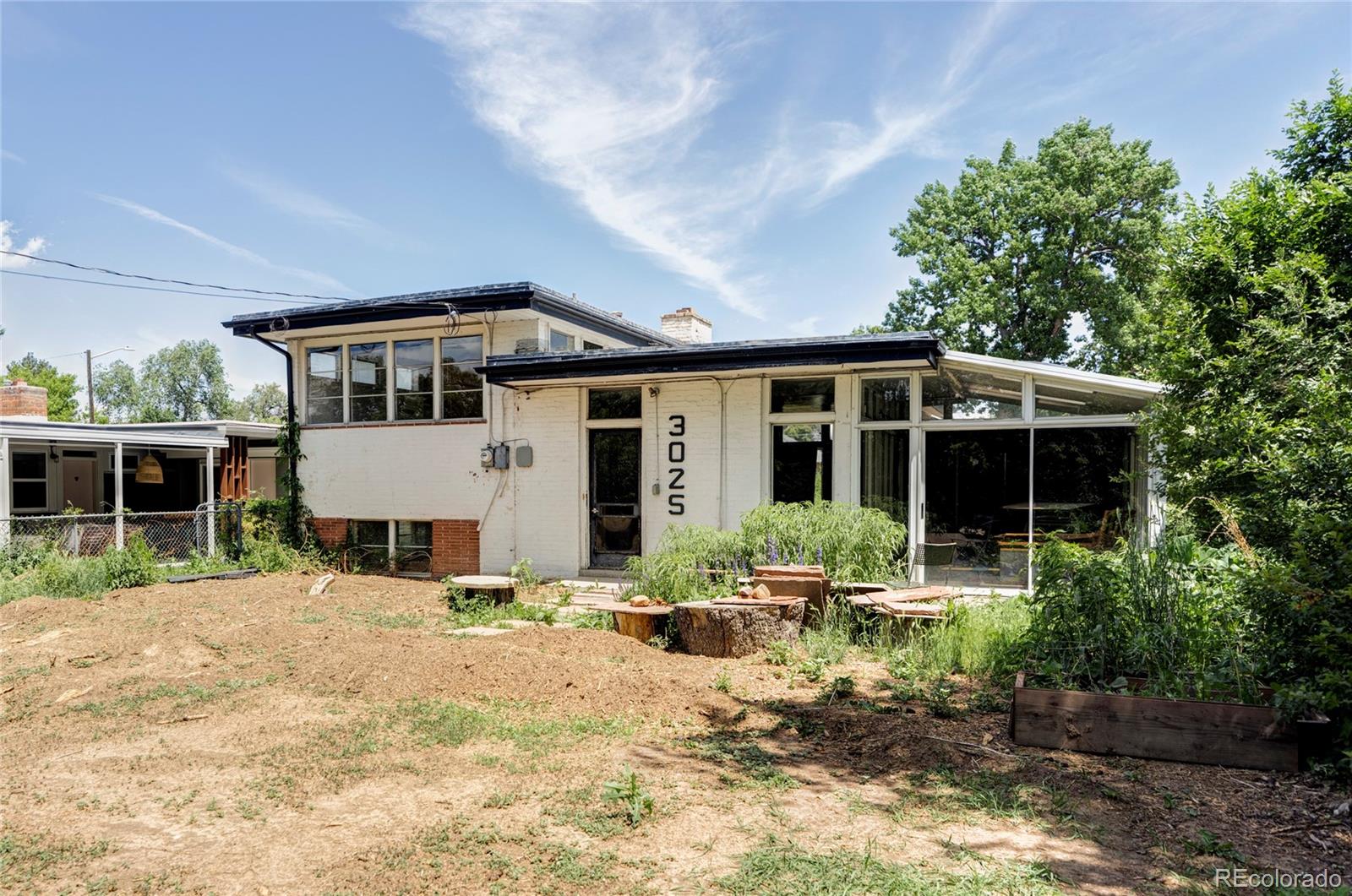 3025 Glencoe Street Denver, CO 80207 - Photo 25 of 26 a front view of a house with a yard outdoor seating and garage