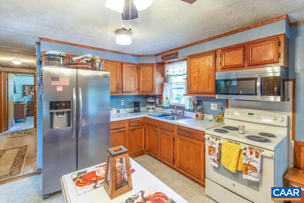 7219 Amicus Road Ruckersville, VA 22968 - Photo 18 of 35 a kitchen with stainless steel appliances granite countertop a sink stove and refrigerator