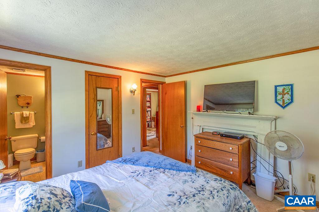 7219 Amicus Road Ruckersville, VA 22968 - Photo 32 of 35 a bedroom with a bed and a flat screen tv