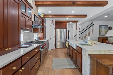 a kitchen with stainless steel appliances granite countertop a sink and a stove