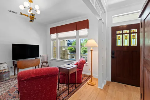 a living room with furniture a flat screen tv and a floor to ceiling window