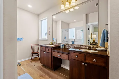 a bathroom with a sink double vanity granite and a mirror