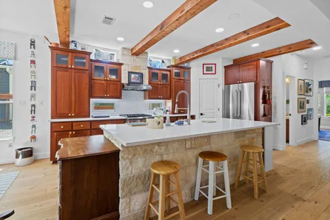 a kitchen with stainless steel appliances granite countertop a table chairs and a refrigerator