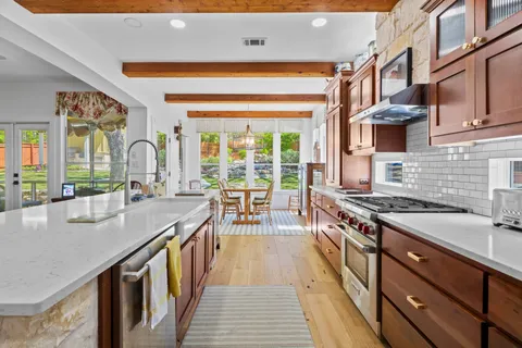 a kitchen with stainless steel appliances granite countertop a stove and a sink