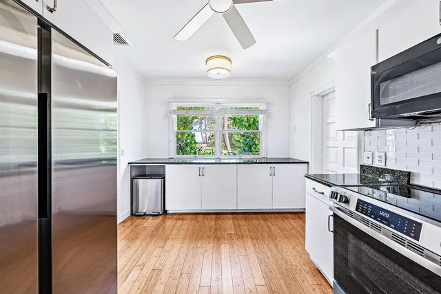 a kitchen with stainless steel appliances a stove a refrigerator and a window