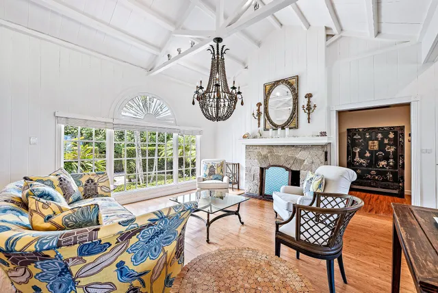 a living room with furniture a fireplace and a chandelier