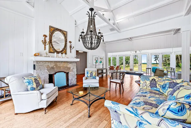 a living room with furniture a fireplace and a chandelier