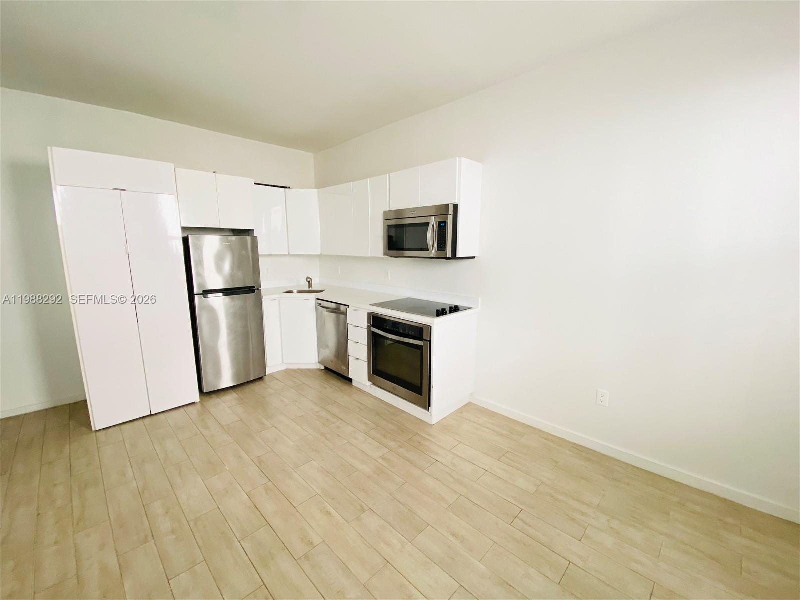 1611 Meridian Avenue, Unit 305 Miami Beach, FL 33139 - Photo 2 of 17 a view of a kitchen with a sink stove refrigerator and microwave