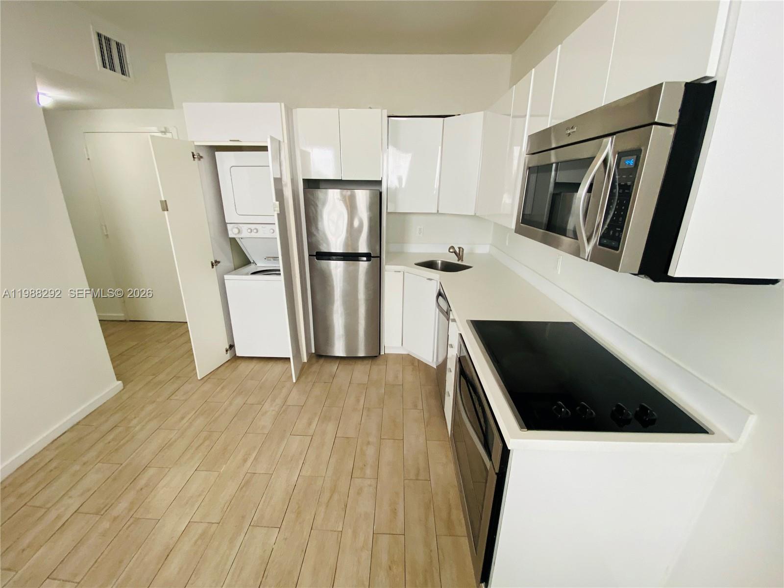 1611 Meridian Avenue, Unit 305 Miami Beach, FL 33139 - Photo 3 of 17 a kitchen with a refrigerator a microwave and sink