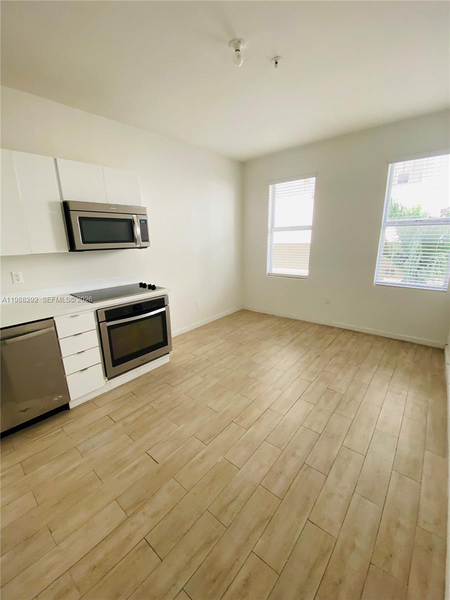 1611 Meridian Avenue, Unit 305 Miami Beach, FL 33139 - Photo 5 of 17 a view of an empty room with wooden floor and a window