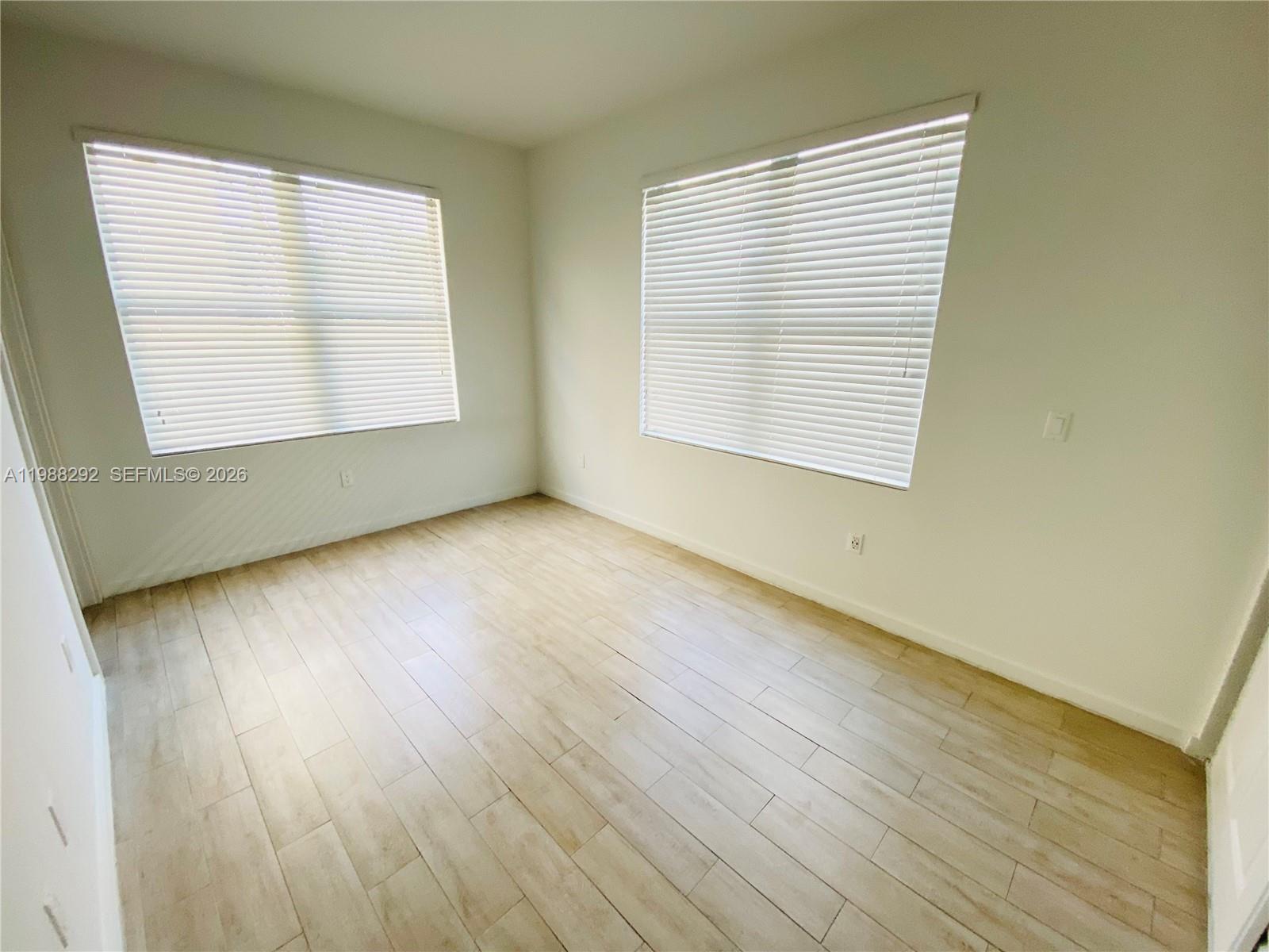1611 Meridian Avenue, Unit 305 Miami Beach, FL 33139 - Photo 8 of 17 a view of an empty room with wooden floor and a window