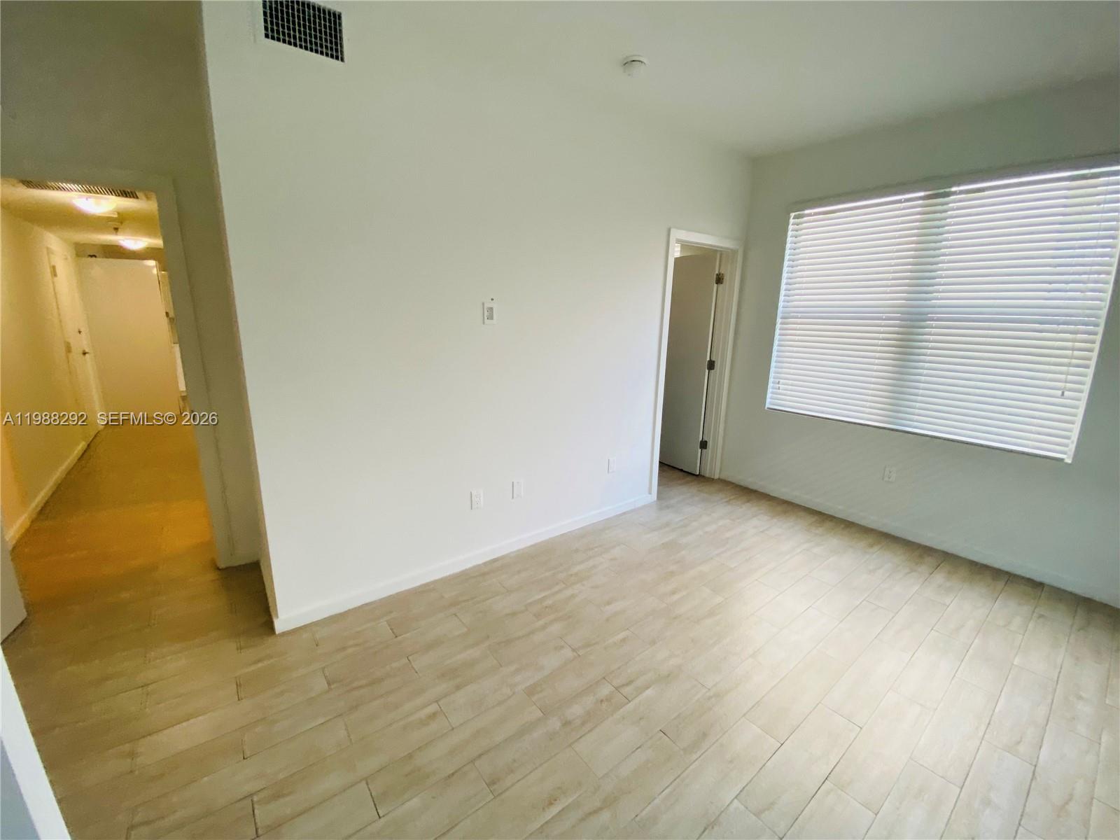 1611 Meridian Avenue, Unit 305 Miami Beach, FL 33139 - Photo 10 of 17 an empty room with wooden floor and windows