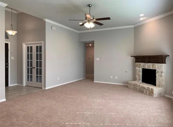 a view of a livingroom with a fireplace and a chandelier fan