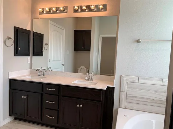 a bathroom with a double vanity sink and mirror