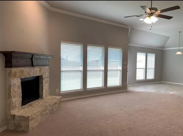 a view of an empty room with a fireplace and a window