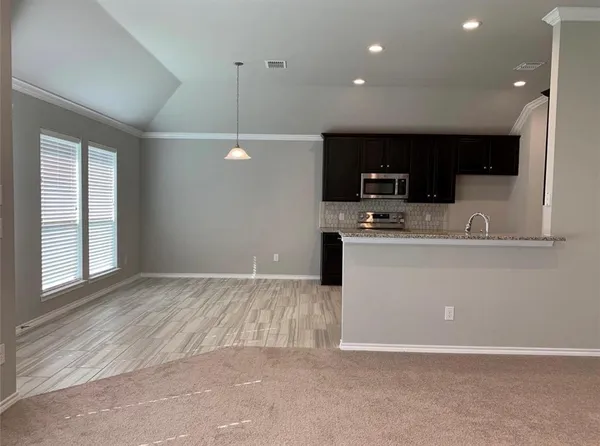 a kitchen with kitchen island a sink stainless steel appliances and window