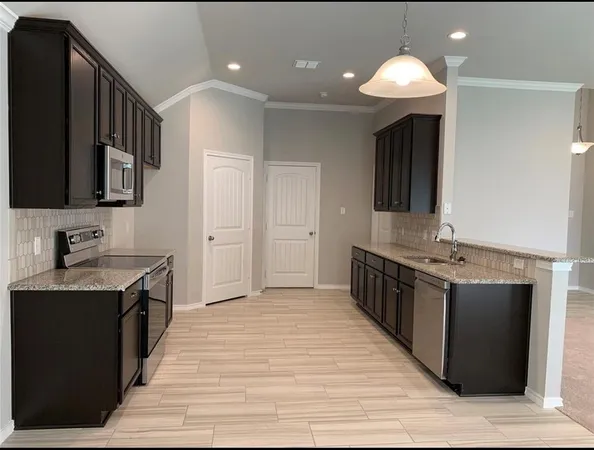 a kitchen with stainless steel appliances granite countertop a sink and a stove