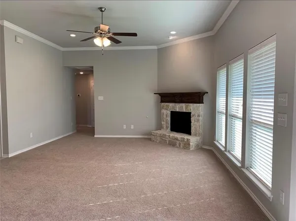an empty room with a fireplace and fan