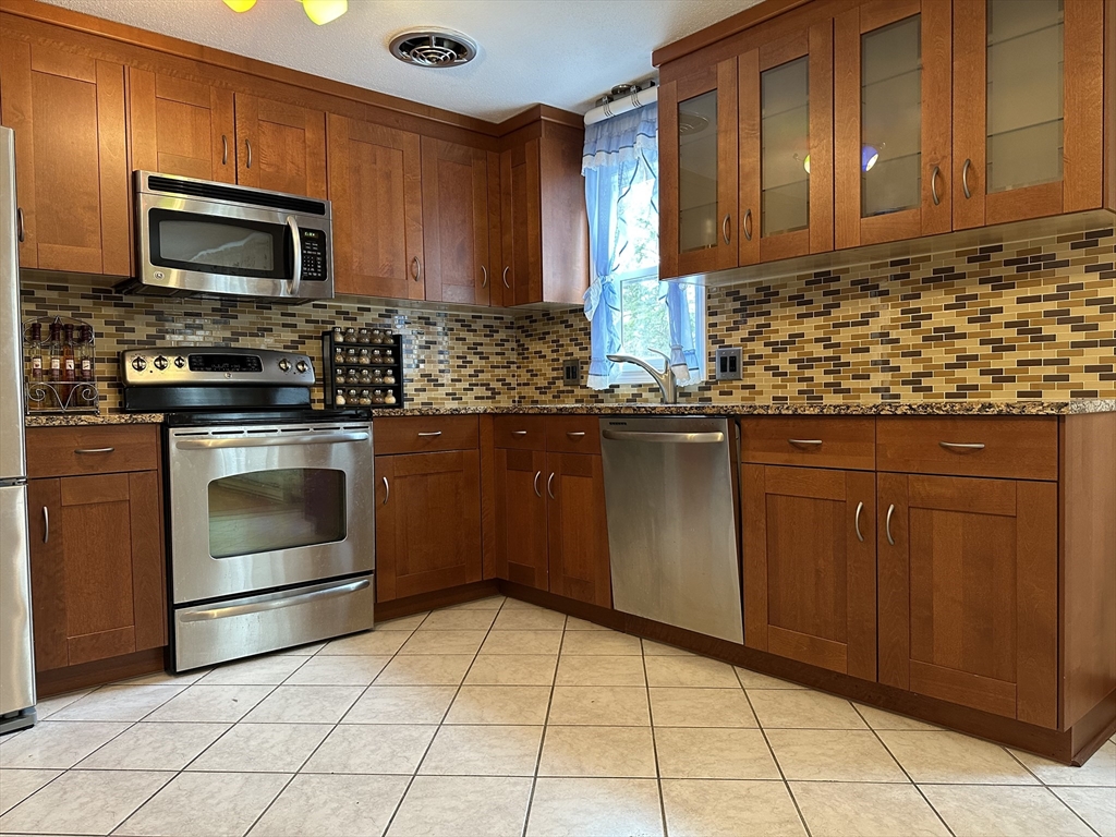 18 Crystal Brook Drive Springfield, MA 01118 - Photo 11 of 20 a kitchen with granite countertop a stove top oven microwave and cabinets