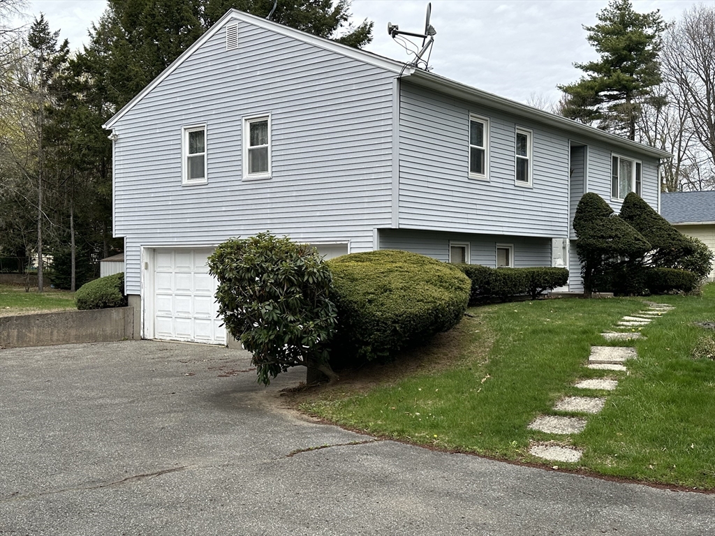 18 Crystal Brook Drive Springfield, MA 01118 - Photo 4 of 20 a view of a house with a yard plants and a large tree