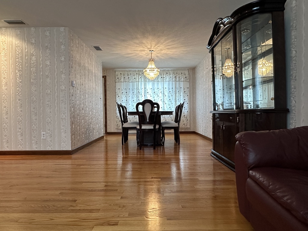 18 Crystal Brook Drive Springfield, MA 01118 - Photo 9 of 20 a dining room with wooden floor a chandelier a glass table and chairs