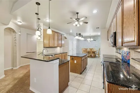 a kitchen with stainless steel appliances granite countertop a sink a stove and a refrigerator