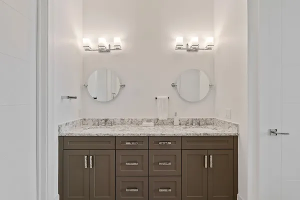 a bathroom with a granite countertop sink a mirror and shower