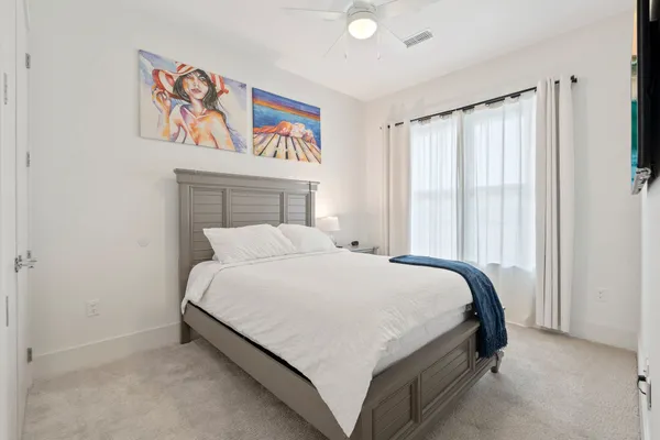 a spacious bedroom with a bed and a chandelier