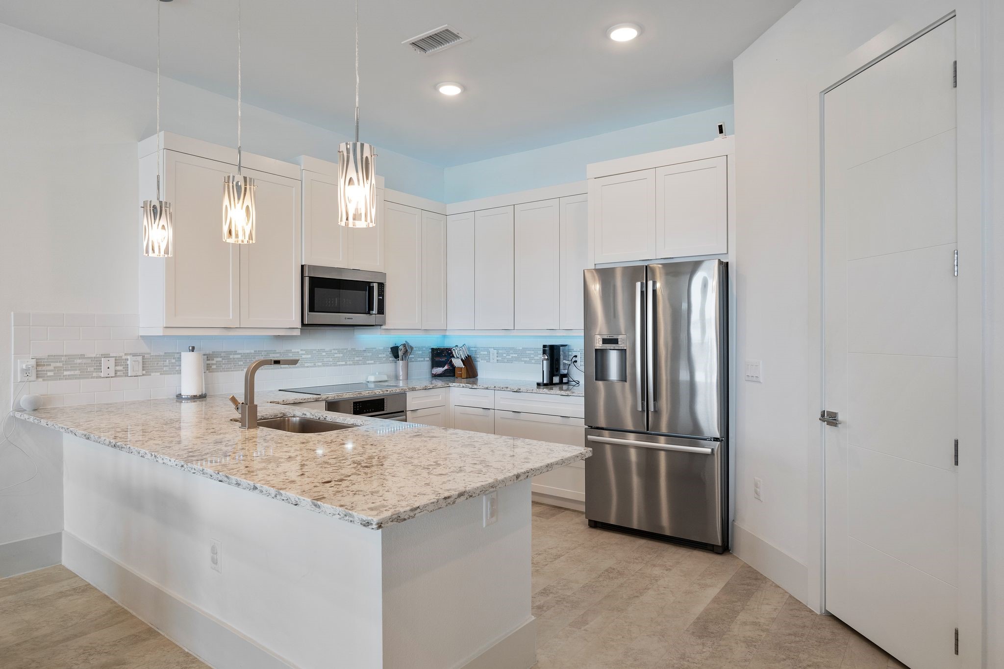 199 Waterpoint Court, Unit 213 Montgomery, TX 77356 - Photo 8 of 46 a kitchen with granite countertop a refrigerator and a sink