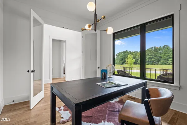 an empty room with ceiling fan and windows