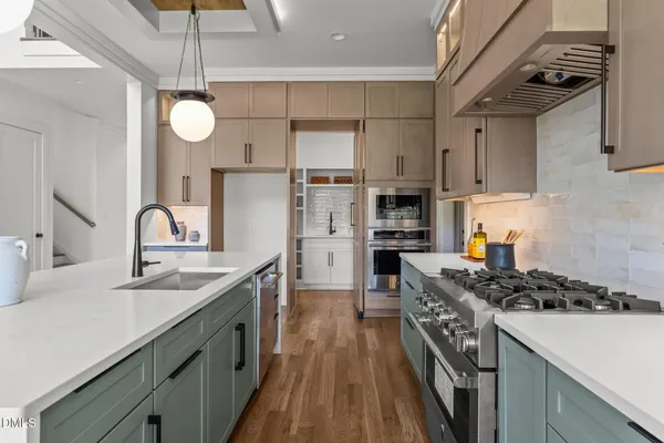 a kitchen with stainless steel appliances a dining table and chairs