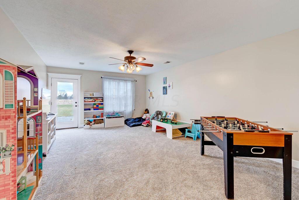 4045 Russell Road Mount Gilead, OH 43338 - Photo 35 of 74 • Gray carpet • Tan painted walls • Lighted ceiling fan • Window with door