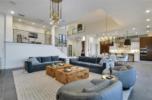 a living room with furniture kitchen view and a chandelier