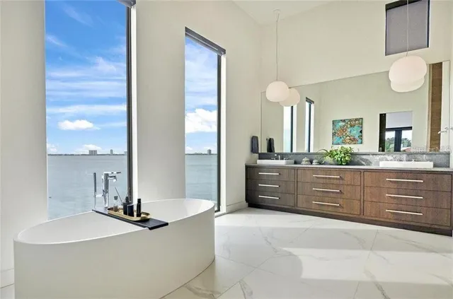 a spacious bathroom with a granite countertop sink a mirror and a bathtub