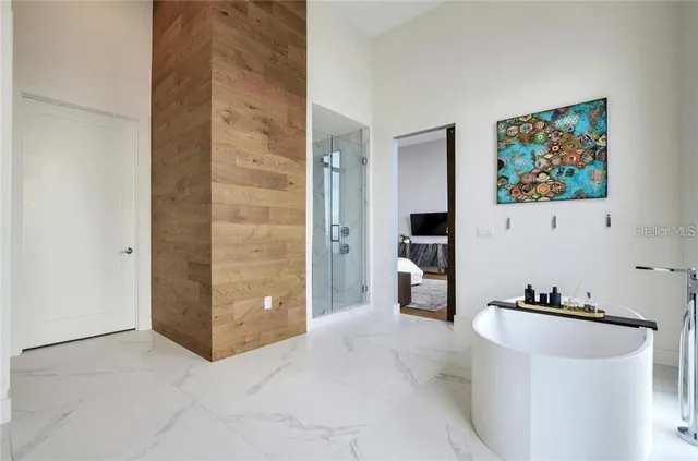 a view of a hallway with bathroom and mirror