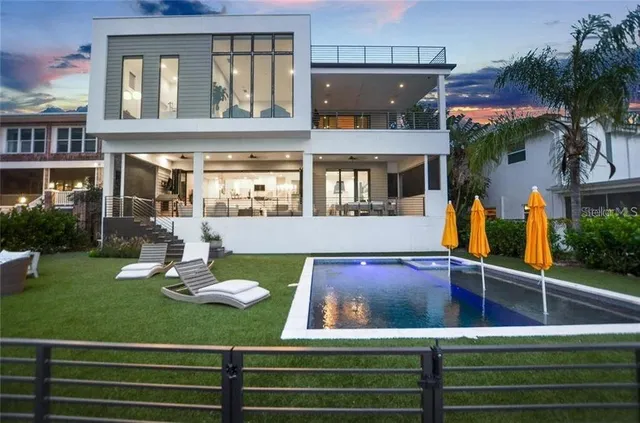 a view of a house with pool and chairs
