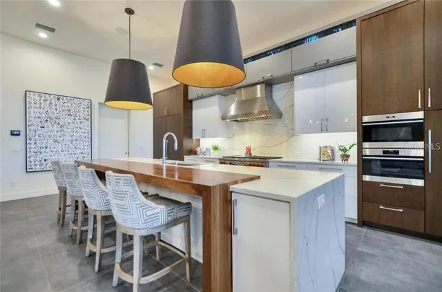 a kitchen with stainless steel appliances a table chairs and a refrigerator